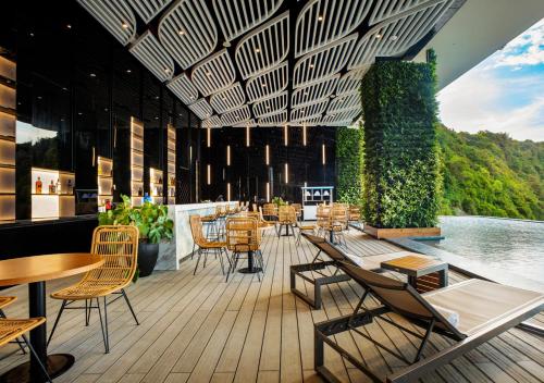 a restaurant with chairs and tables on a deck at Flamingo Resort Cat Ba in Cat Ba