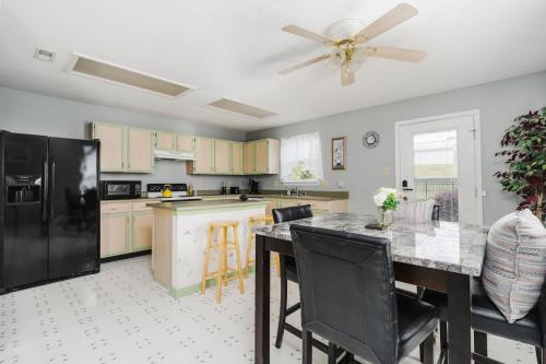a kitchen with a black refrigerator and a table with chairs at Cozy Home Plainfield Indy in Plainfield