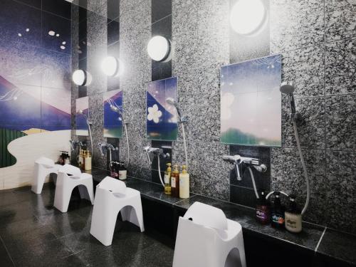 a bathroom with three sinks and four toilets at hotel MONday Premium TOYOSU in Tokyo