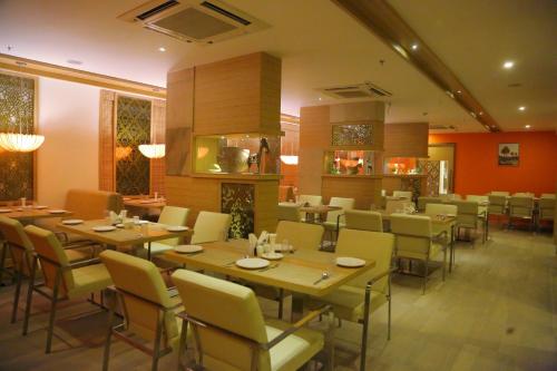 una sala da pranzo con tavoli e sedie in legno di Hotel Park N a Vijayawāda