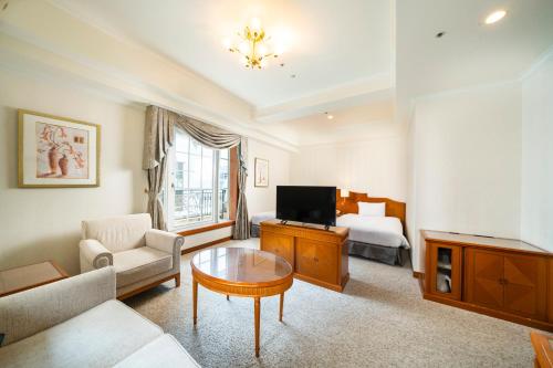 a living room with a couch and a tv and a bed at KOKO HOTEL Osaka Shinsaibashi in Osaka