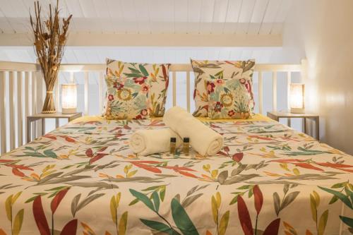 a bedroom with a bed with a floral bedspread at Ti Kaz Oreo - Cosy Plage & confort - Wiskeys in Saint-Gilles les Bains
