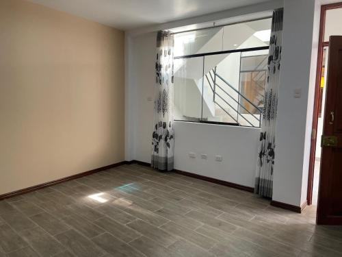 une pièce vide avec une grande fenêtre avec des rideaux dans l'établissement Dreaming wasi Standar, à Puno