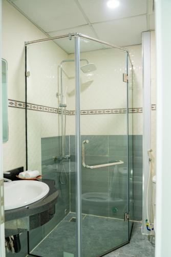 a bathroom with a glass shower and a sink at Garden Hotel II in Ha Giang