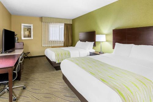 a hotel room with two beds and a flat screen tv at Best Western Gaylord in Gaylord