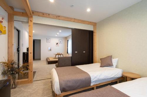 a hotel room with two beds and a table at UCHI Susukino 5.7 in Sapporo