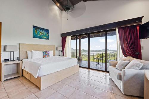 a bedroom with a bed and a couch and a balcony at Spectacular Ocean Views Infinity Pool in Potrero