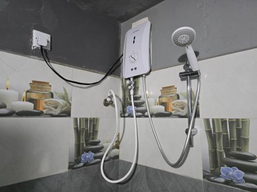 a shower in a bathroom with a blow dryer at Ceylon Resort Wilpattu in Wilpattu