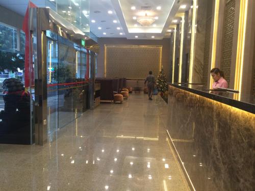 a lobby of a building with people walking down a hallway at Hotel Grand Central in Singapore