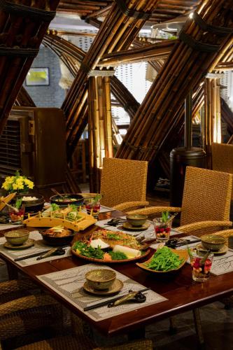 a wooden table with plates of food on it at Flamingo Resort Dai Lai in Ngọc Quang
