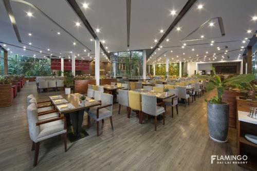 a restaurant with tables and chairs in a room at Flamingo Resort Dai Lai in Ngọc Quang