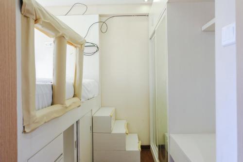 a bedroom with a bed and a mirror at Strategic 2BR Gateway Ahmad Yani Cicadas Apartment By Travelio in Bandung