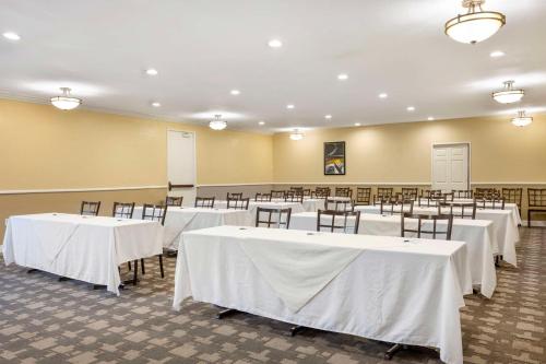 a room filled with tables and chairs with white table cloth at Best Western Oceanside Inn in Oceanside