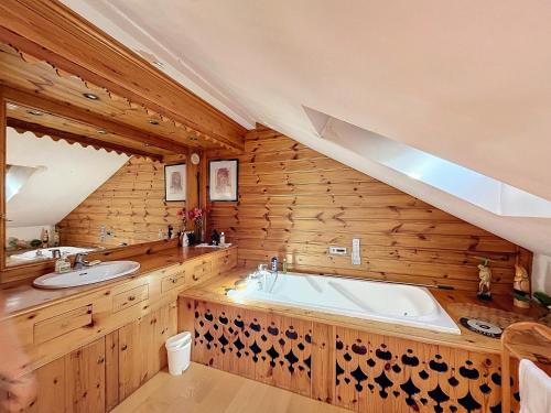 un bagno con una grande vasca e due lavandini di Chalet typique avec sauna et cheminée à Méribel, proche de la télécabine - FR-1-688-96 a Les Allues