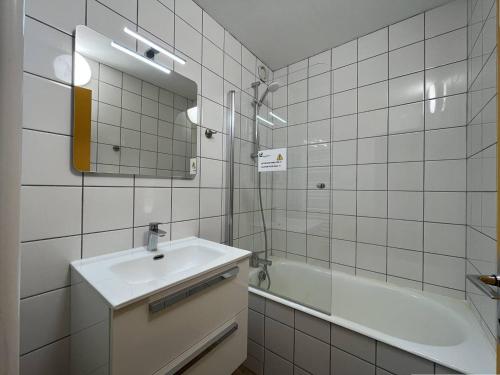 une salle de bain avec un lavabo, une baignoire et un miroir dans l'établissement Appartement 3 pièces pour 6 personnes à Plan Peisey, accès direct pistes - FR-1-757-121, à Peisey-Nancroix