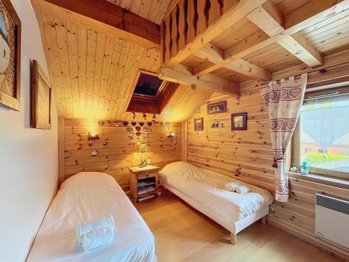 una camera con 2 letti in una baita di tronchi di Chalet typique avec sauna et cheminée à Méribel, proche de la télécabine - FR-1-688-96 a Les Allues