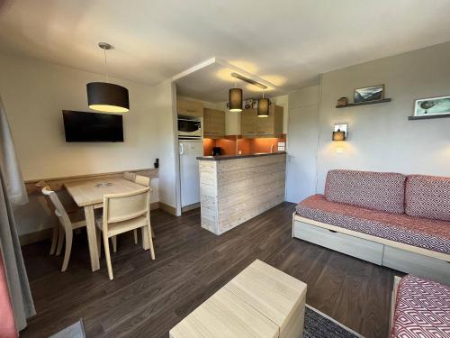 un salon avec un canapé et une table et une cuisine dans l'établissement Appartement cosy à Plagne 1800 avec parking et piscine chauffée - FR-1-351-242, à La Plagne Tarentaise