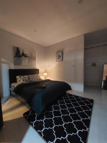 a bedroom with a bed with a black comforter at A&T House Sukabumi in Sukabumi