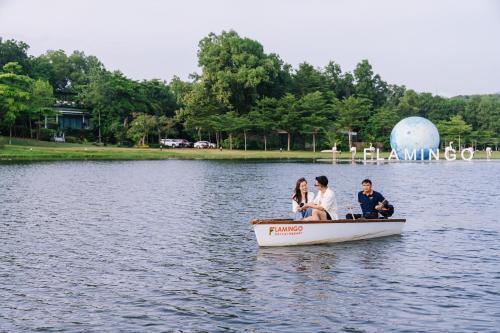 a group of people riding in a boat on a lake at Flamingo Resort Dai Lai in Ngọc Quang