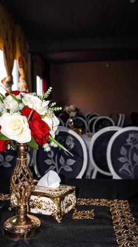 a vase with flowers in it on a table at Hotel Ain Leuh in Aïn Leuh