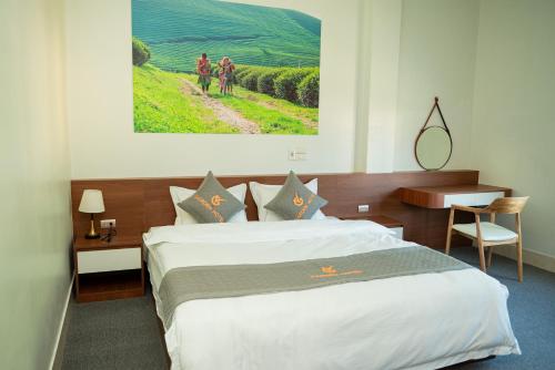 a hotel room with a bed and two people walking down a road at Garden Hotel II in Ha Giang