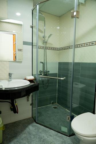 a bathroom with a shower and a toilet and a sink at Garden Hotel II in Ha Giang