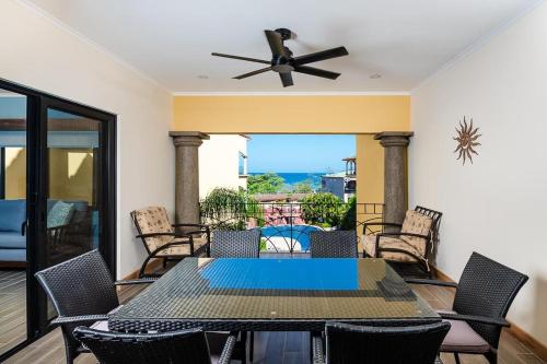 a dining room with a table and chairs and a ceiling fan at Wake Up to Ocean Views, Pool, Walk to Sandy Beach in Tamarindo