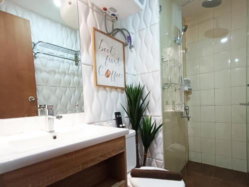 a bathroom with a sink and a toilet and a shower at Comfort and Strategic 2BR Apartment at Vida View Makassar By Travelio in Pampang