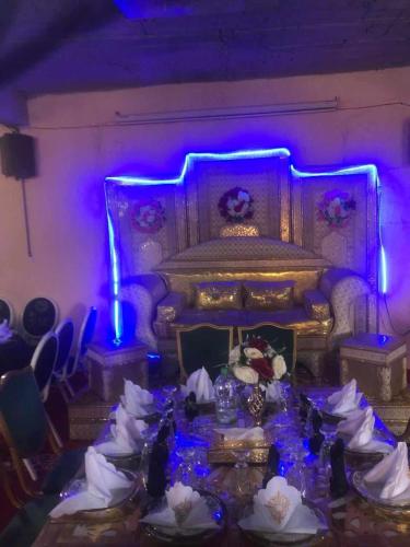 a room with a bed and a table with flowers at Hotel Ain Leuh in Aïn Leuh
