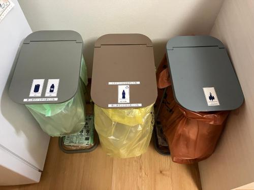 a group of trash cans sitting on the floor at ゲストハウスわたうさぎ in Tsuruoka