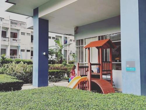 a child playing on a playground in front of a building at Studio Seaview Jomtien floor12 23sqm in Jomtien Beach
