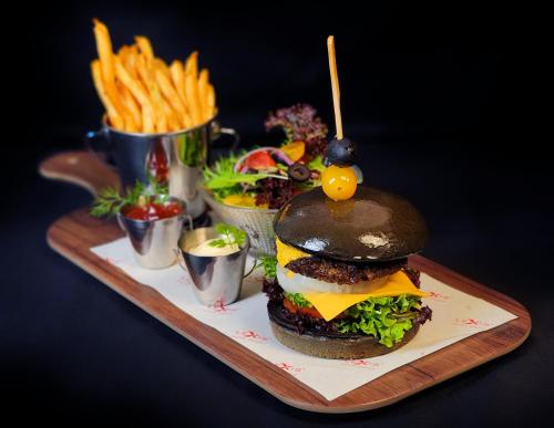 a plate with a hamburger and french fries on a table at Imperial Lexis Kuala Lumpur in Kuala Lumpur