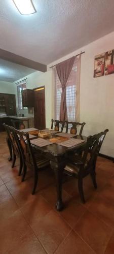 a dining room table and chairs in a room at Casa Bugambilias in Ajaxá
