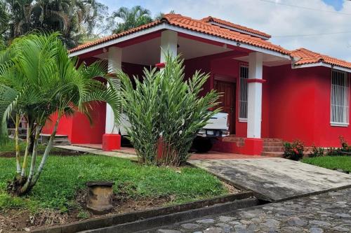 a red house with palm trees in front of it at Casa Bugambilias in Ajaxá