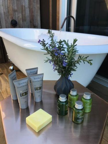 a table with a vase of flowers and a bath tub at Amaroo Valley Springs in Barrengarry