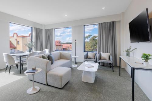 a living room with a couch and a tv at Punthill Tuggeranong in Canberra
