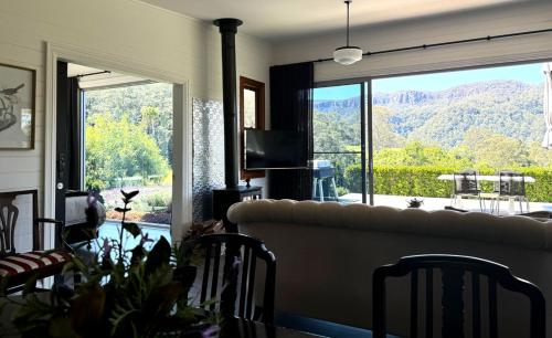 a living room with a couch and a large window at Amaroo Valley Springs in Barrengarry