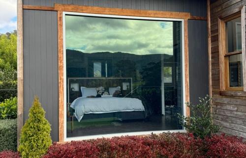 a bedroom with a bed outside of a window at Amaroo Valley Springs in Barrengarry