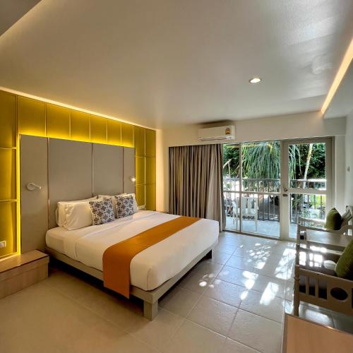 a bedroom with a large bed with a yellow wall at Sunshine Garden Resort in North Pattaya