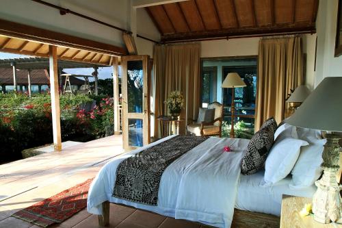 a bedroom with a bed and a patio at Bangsring Breeze in Banyuwangi