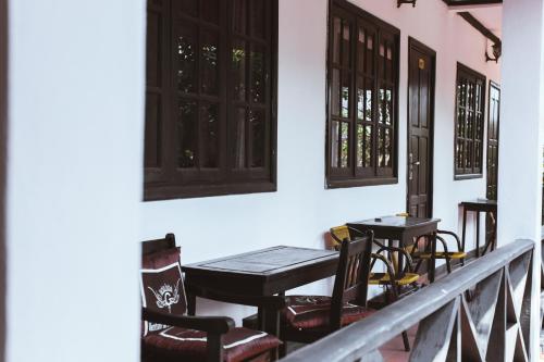 a balcony with tables and chairs and windows at Vientiane Garden Villa Hotel And Coffee in Vientiane