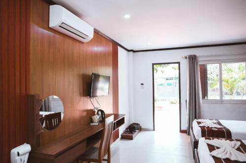 a hotel room with a bed and a mirror at Vientiane Garden Villa Hotel And Coffee in Vientiane
