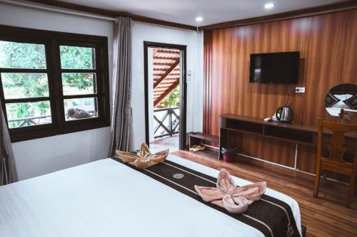 a bedroom with a large bed and a television at Vientiane Garden Villa Hotel And Coffee in Vientiane
