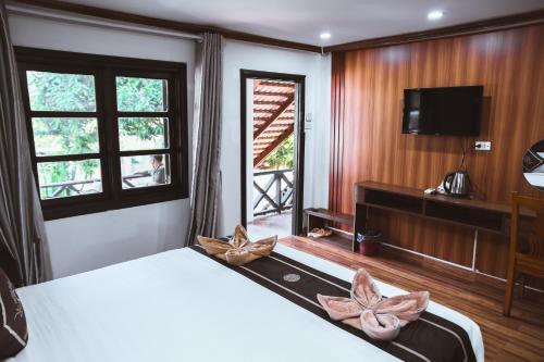 a bedroom with a bed and a flat screen tv at Vientiane Garden Villa Hotel And Coffee in Vientiane