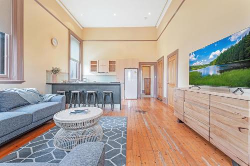a living room with a couch and a tv at Clocktower Suites in Echuca