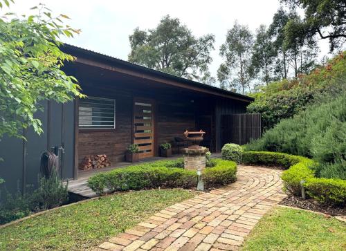 a house with a brick walkway in front of it at Amaroo Valley Springs in Barrengarry