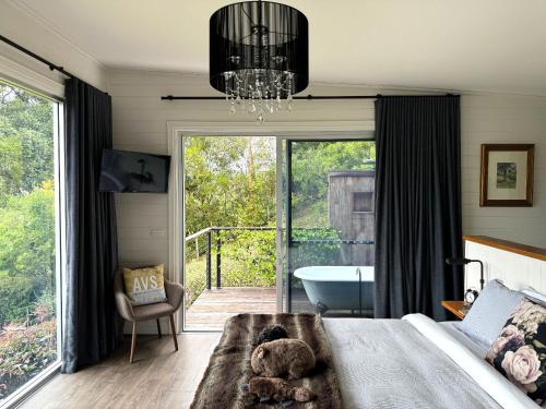 a bedroom with a bed with a tub and a chandelier at Amaroo Valley Springs in Barrengarry