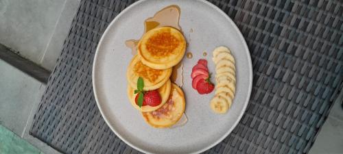 a plate of breakfast food with pancakes and strawberries at The Wayan House Ubud in Ubud