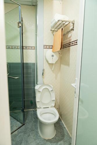 a bathroom with a toilet and a glass shower at Garden Hotel II in Ha Giang