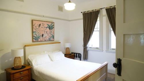 a bedroom with a white bed and a window at Stay on March in Orange